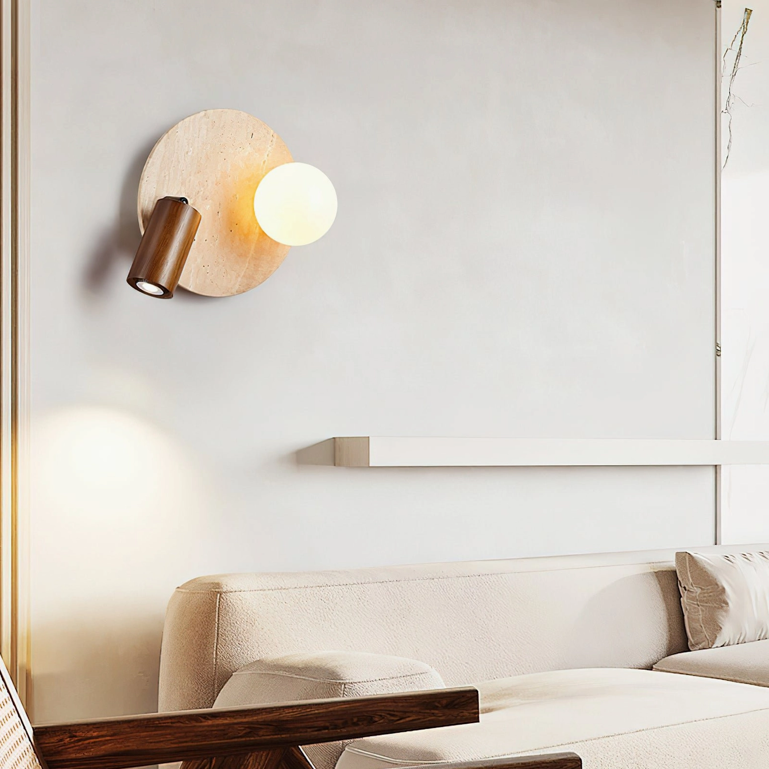Luka Travertine Wall Lamp mounted above fabric sofa in modern living room lounge space with warm indirect lighting and minimalist aesthetic