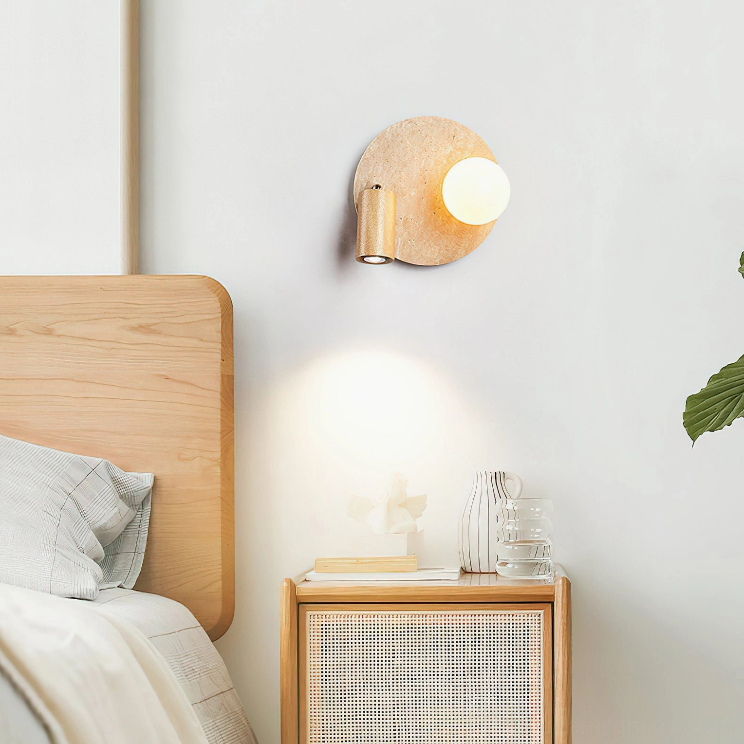 Luka Travertine Wall Lamp in bedroom interior with rattan bedside cabinet and warm wall lighting creating scandinavian minimalist ambiance