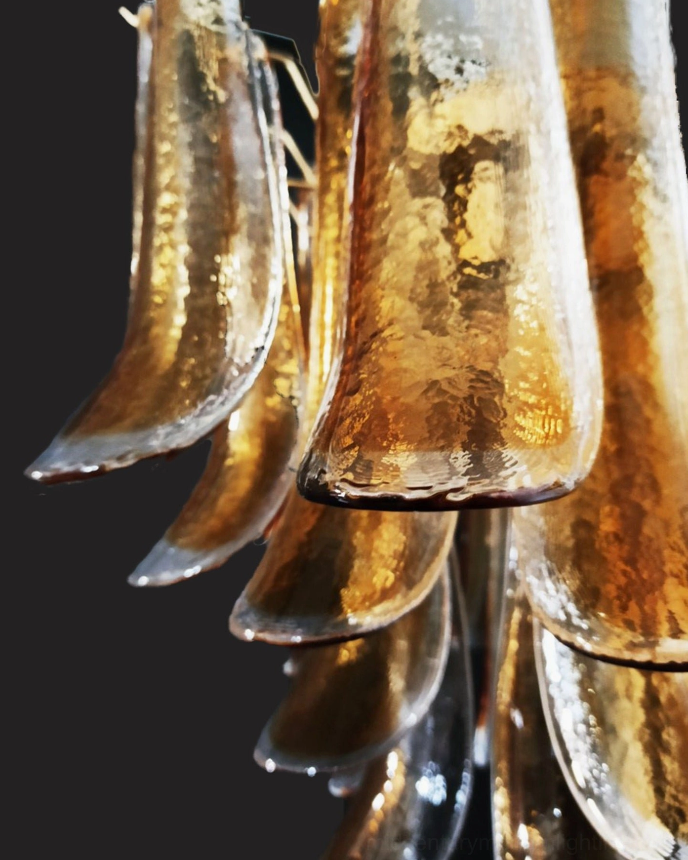 Close-up macro view of Luna amber glass chandelier's hand-blown translucent petals