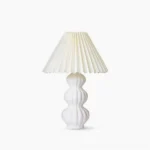 Luna pleated ceramic table lamp with white glazed base and natural beige pleated fabric shade, mid-century modern design