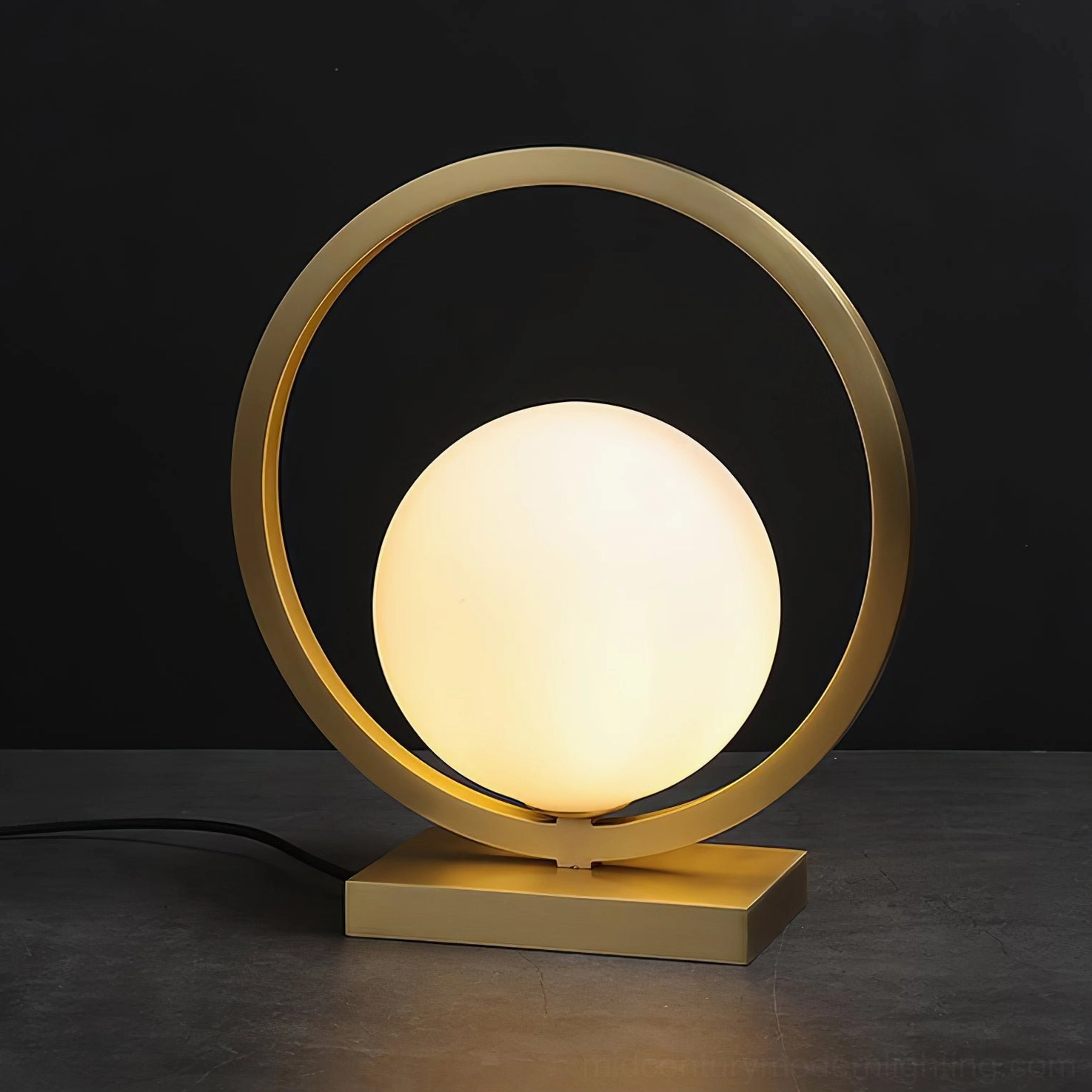 Illuminated Lunar Brass Table Lamp showing warm light diffusion through frosted glass globe
