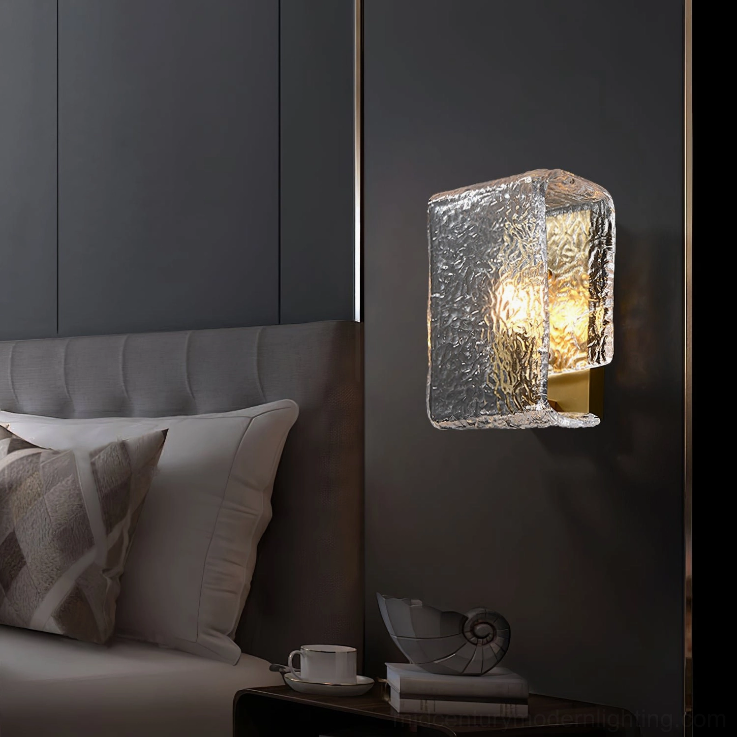 Lunea wall sconce mounted in modern bedroom beside nightstand, side view with soft warm glow