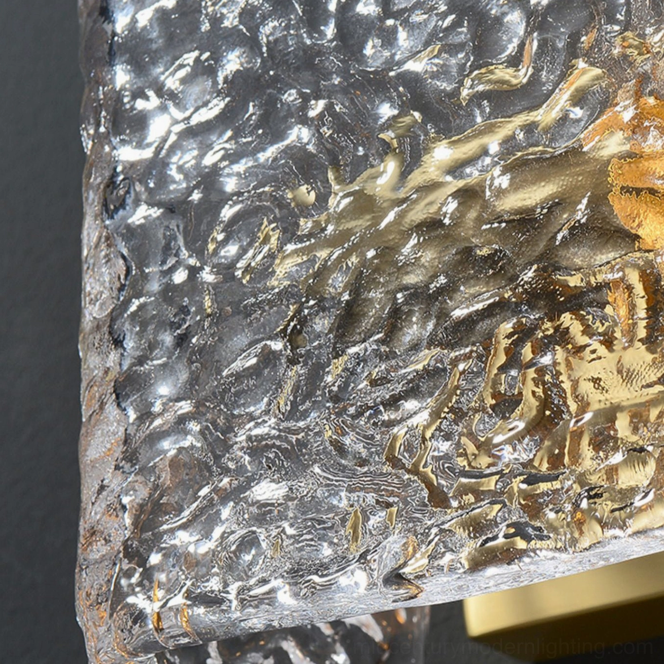Macro close-up of Lunea rippled glass texture with warm golden light reflection and brass mounting