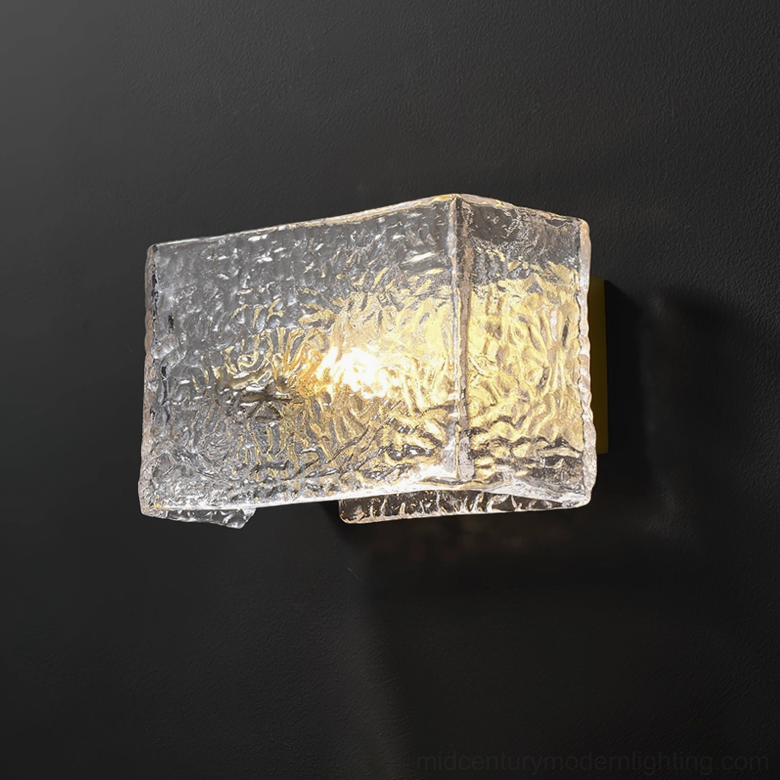 Lunea wall sconce angled front view showing rectangular rippled glass and glowing light on matte grey background