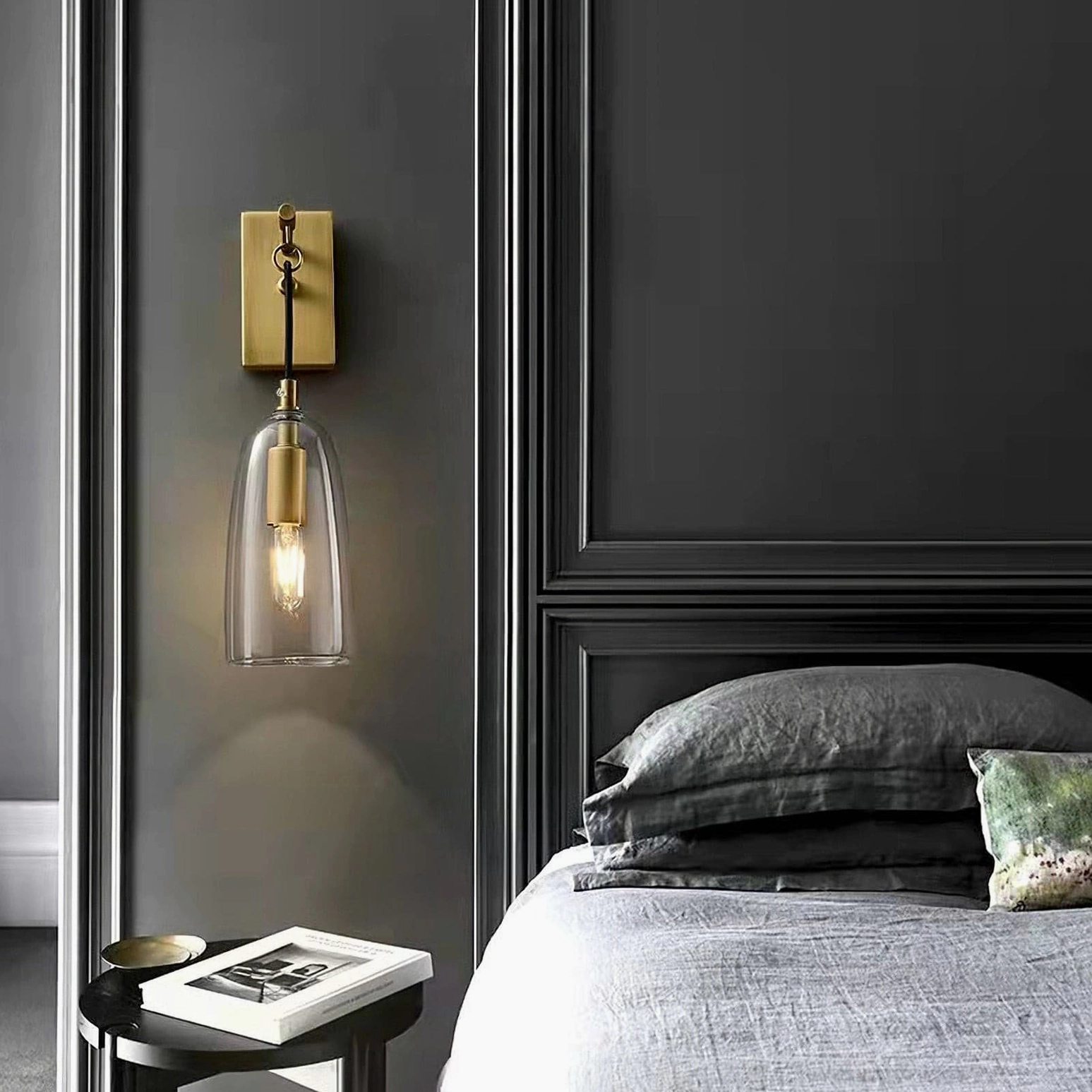Lure wall sconce in bedroom setting with grey accent wall and modern bedside table