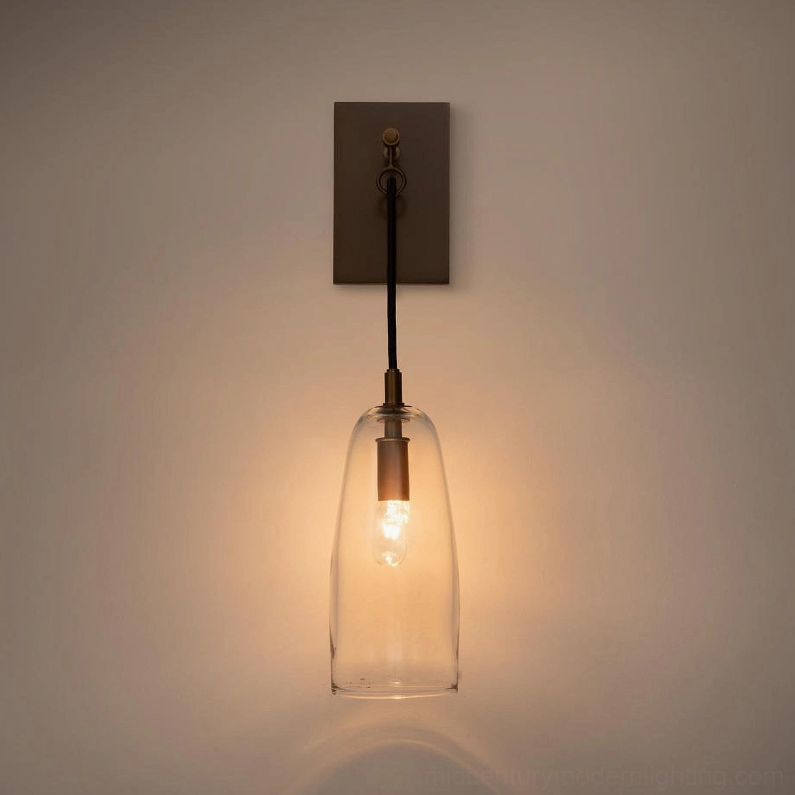 Tapered clear glass wall sconce with brass hardware, Japandi minimalist interior aesthetic