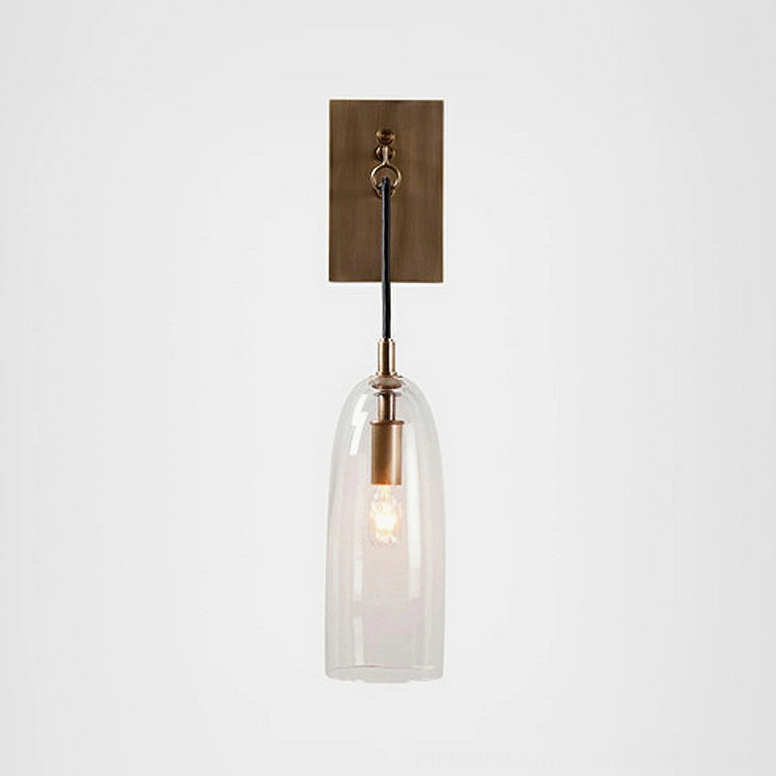 Tapered clear glass cylinder wall sconce with square brass base, minimalist design detail