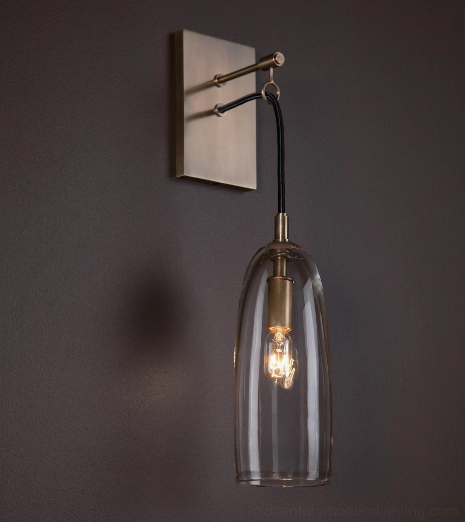 Wall-mounted brass and glass sconce with warm ambient glow, interior design styling