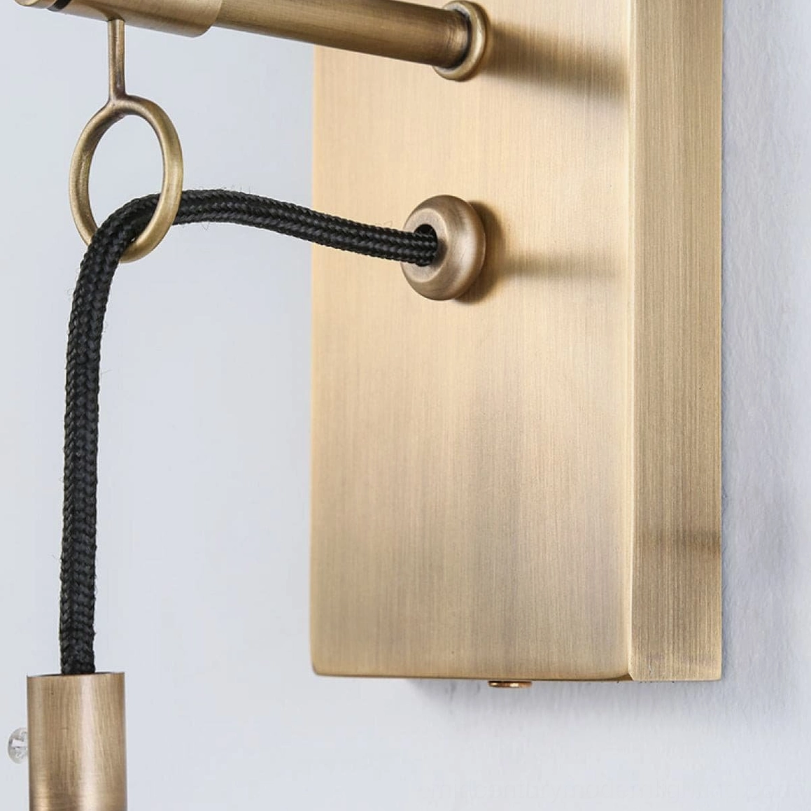 Brass wall sconce positioned in mid-century modern interior setting with neutral tones