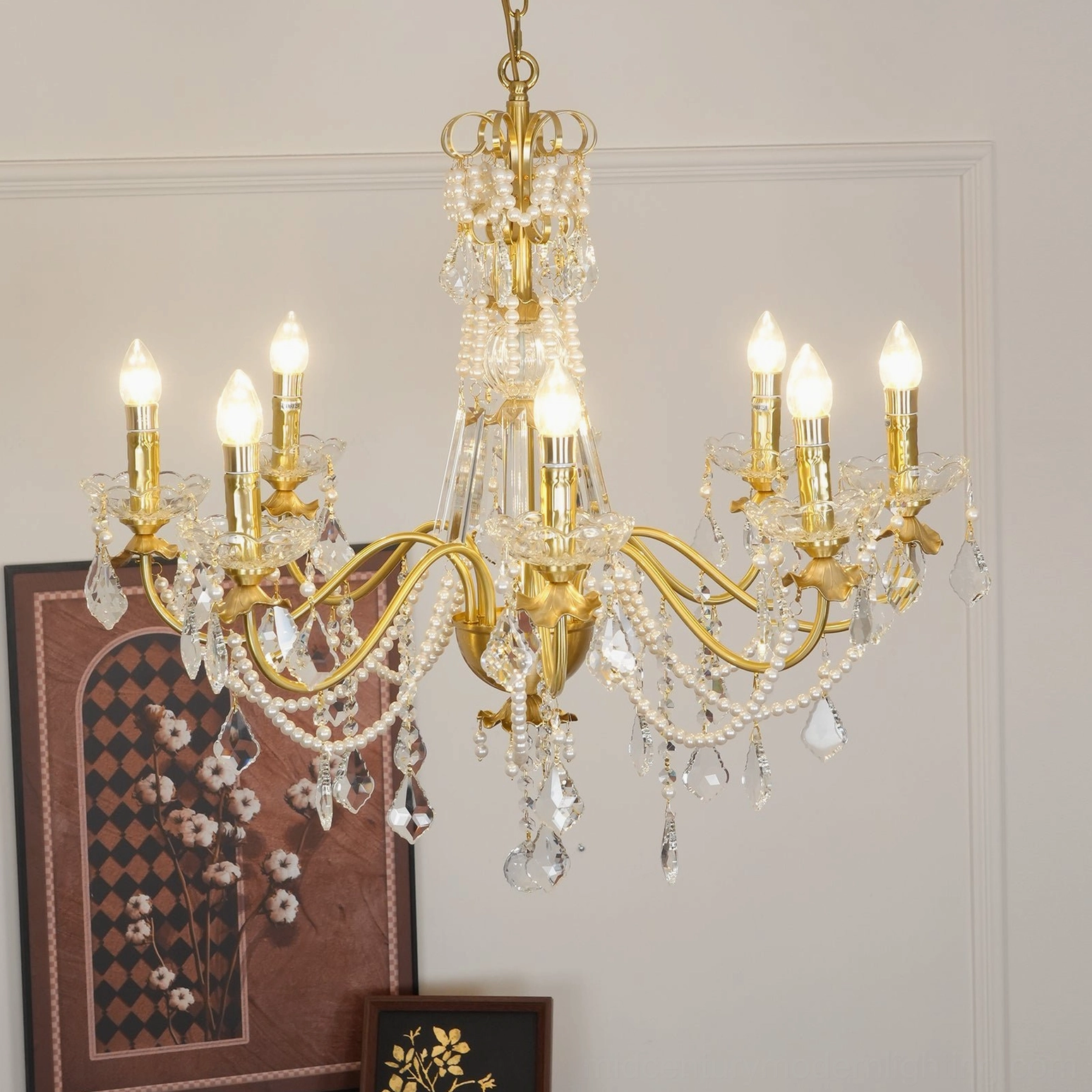 Luxury brass and crystal chandelier with multiple light arms and pearl decorative accents