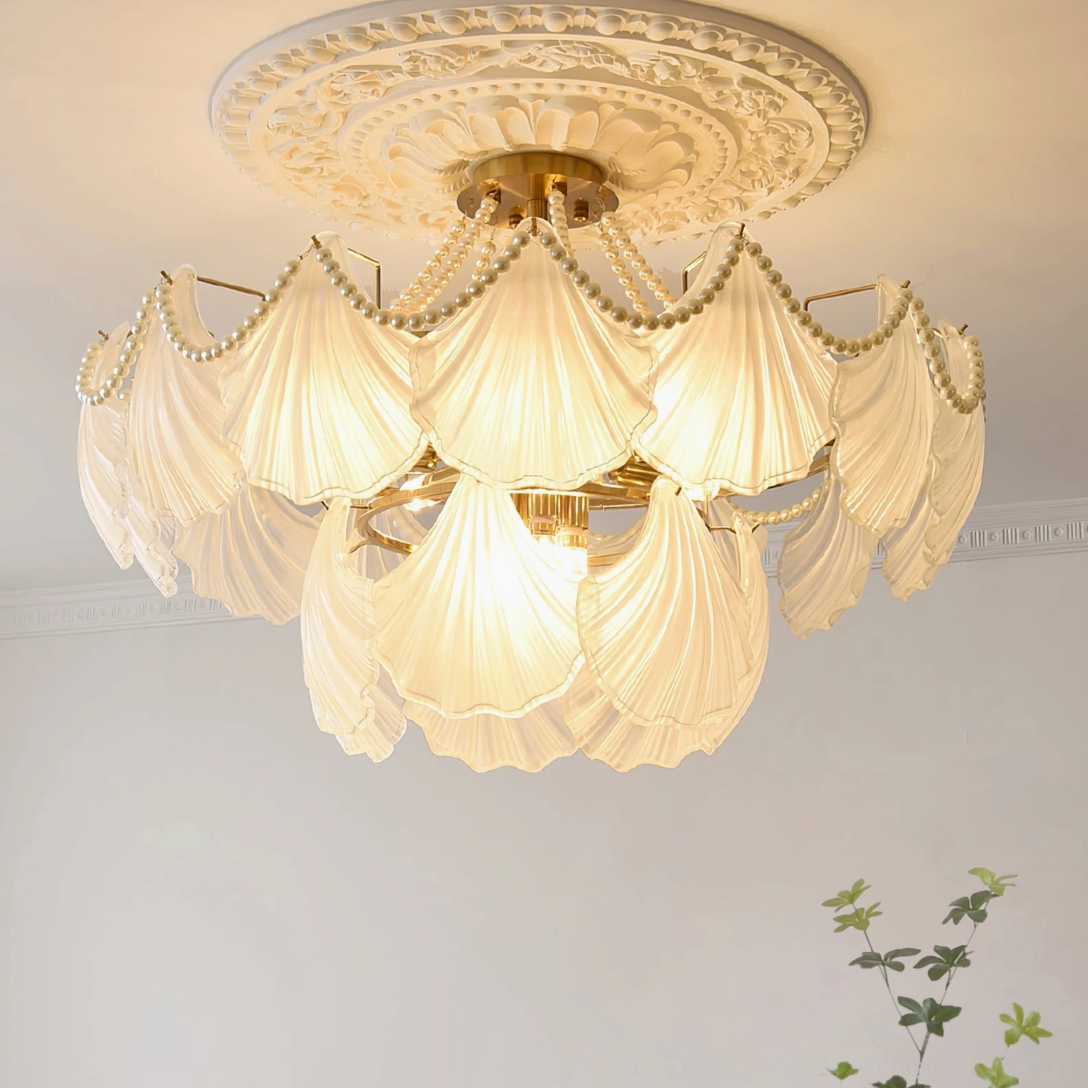 Luxury scallop shell chandelier with brass metallic accents and frosted glass in modern interior setting