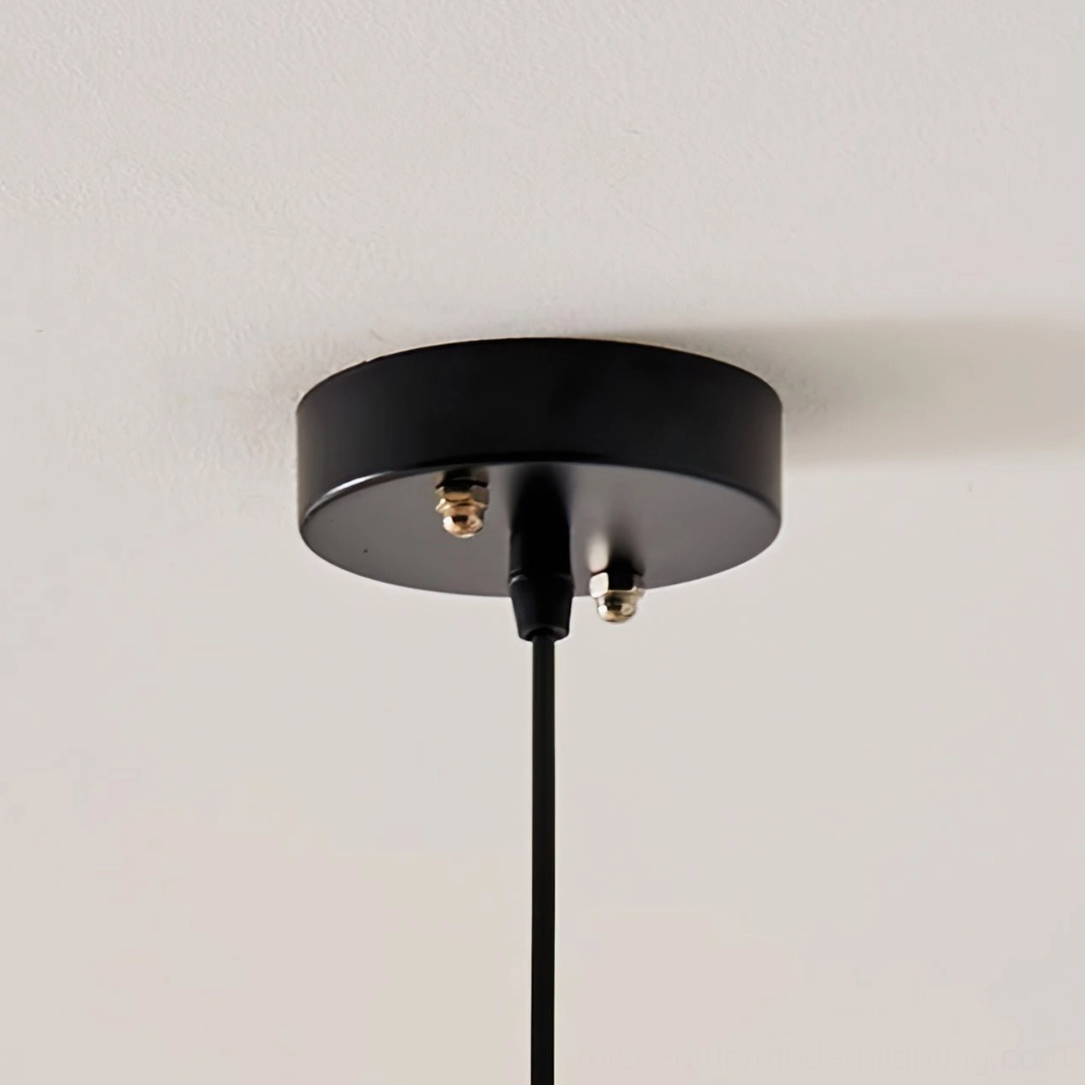Creamy beige abaca pendant lamp with black metal trim hanging in neutral contemporary interior aesthetic