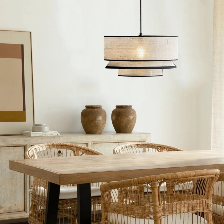 Natural abaca pendant lamp with layered design in formal rustic dining space, paired with rattan chairs and neutral tabletop styling