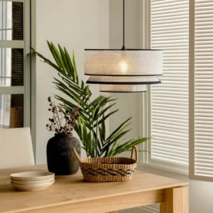 Two-tiered woven pendant light hanging above dining table in warm minimalist interior, wooden table setting with neutral decor