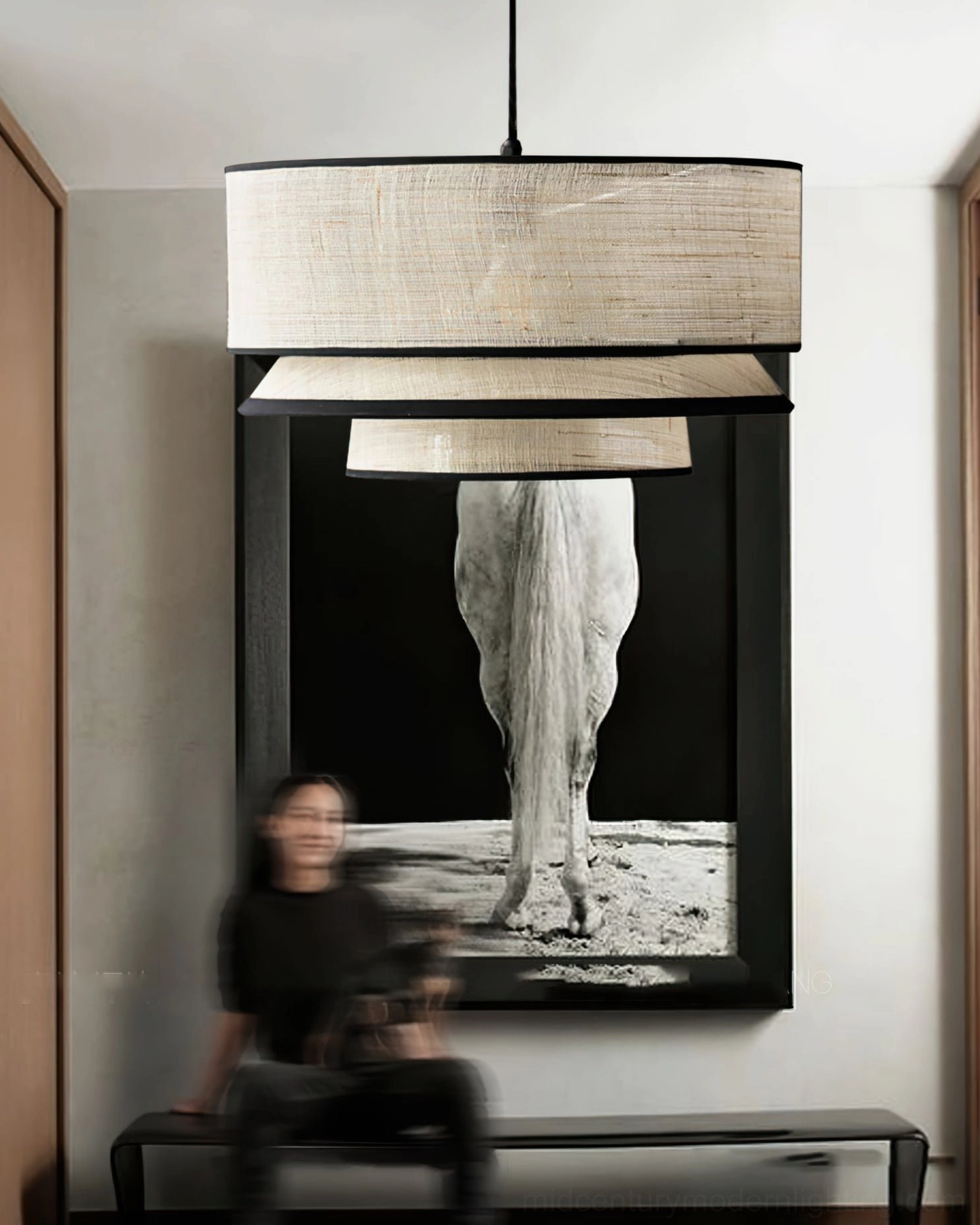 Woven abaca pendant lamp suspended above long bench in art-themed sitting area with elephant wall artwork