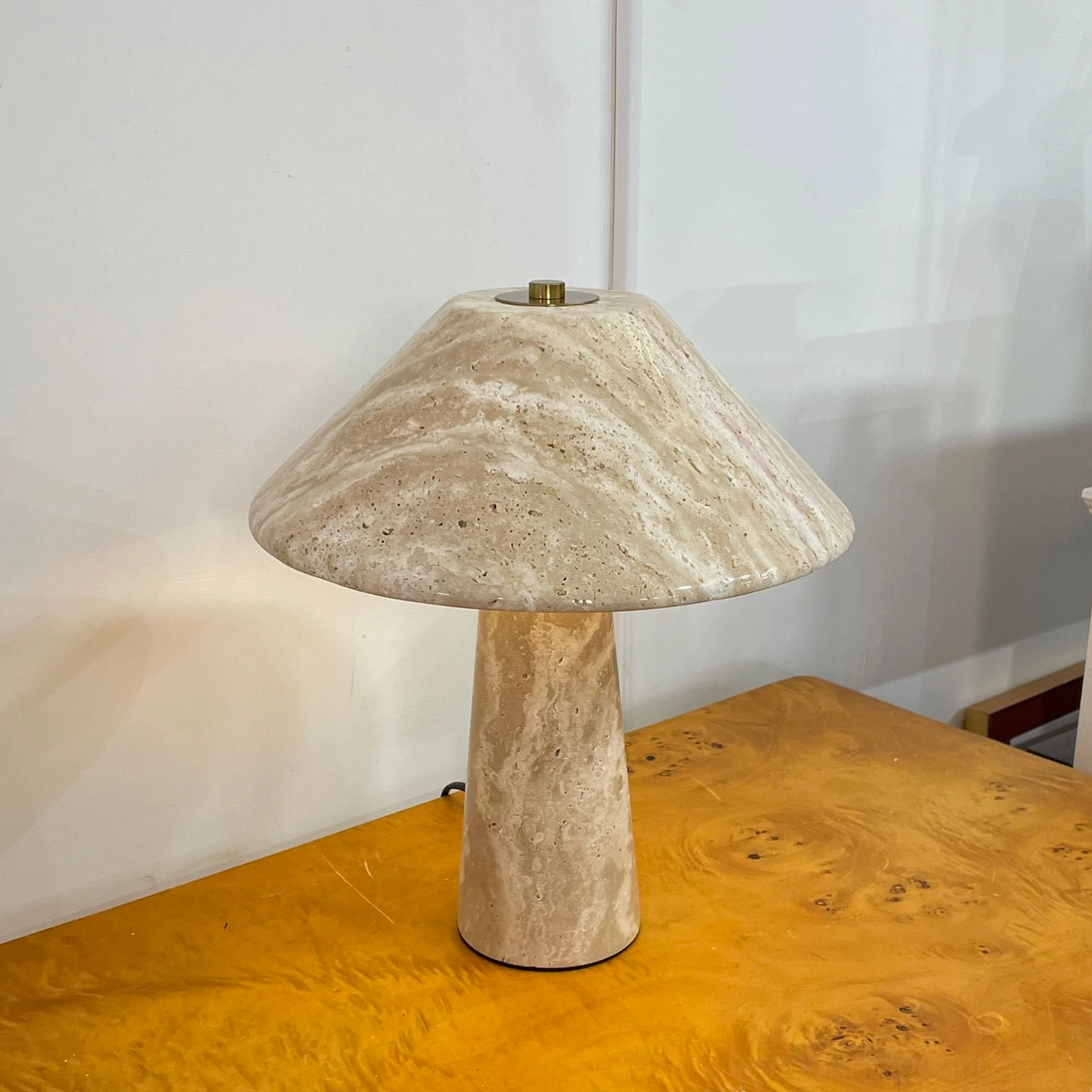 Lydia travertine mushroom lamp three-quarter view on wood table showing natural stone beige color variations