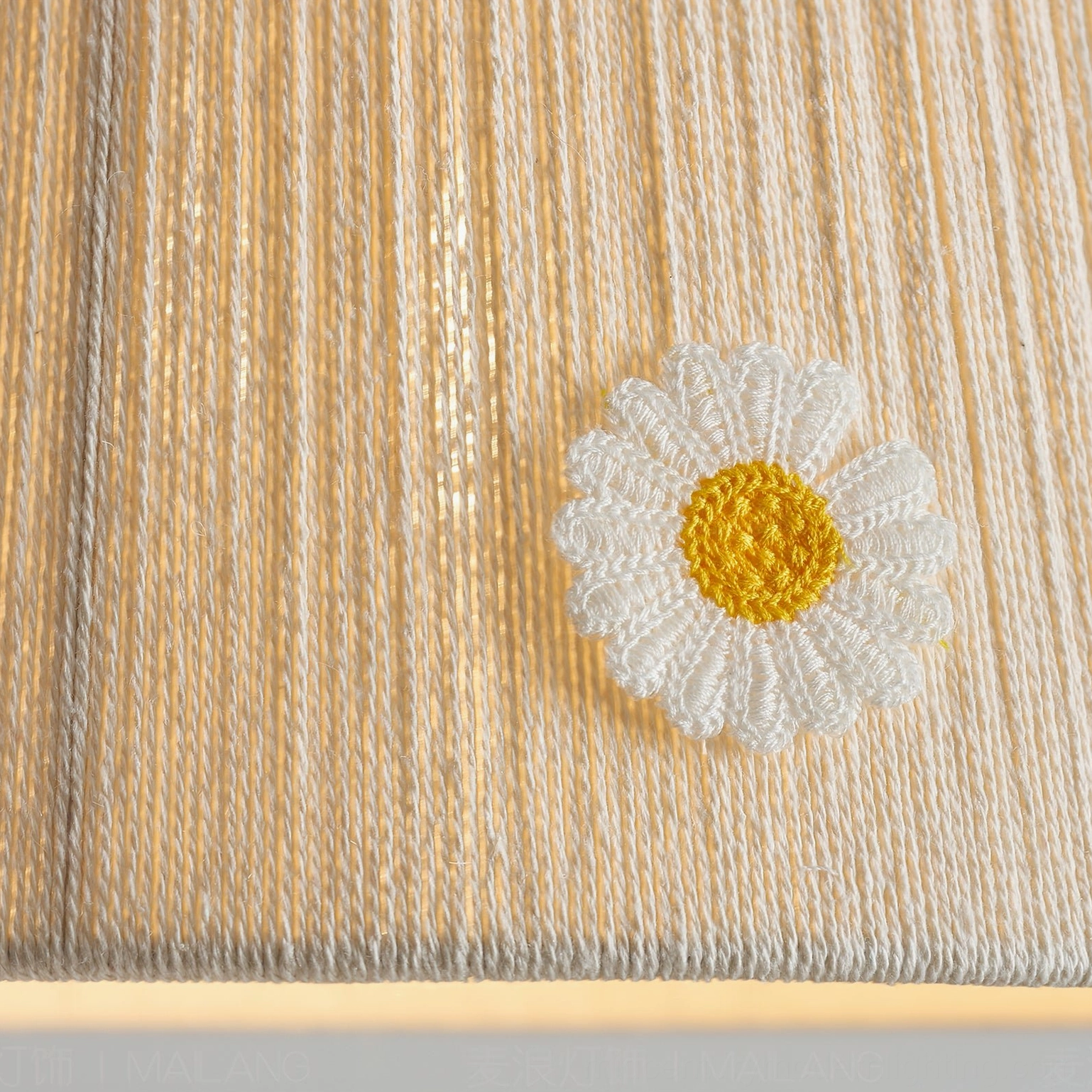 Close-up detail of Lytham pendant light shade showing hand-embroidered daisy pattern and woven linen texture