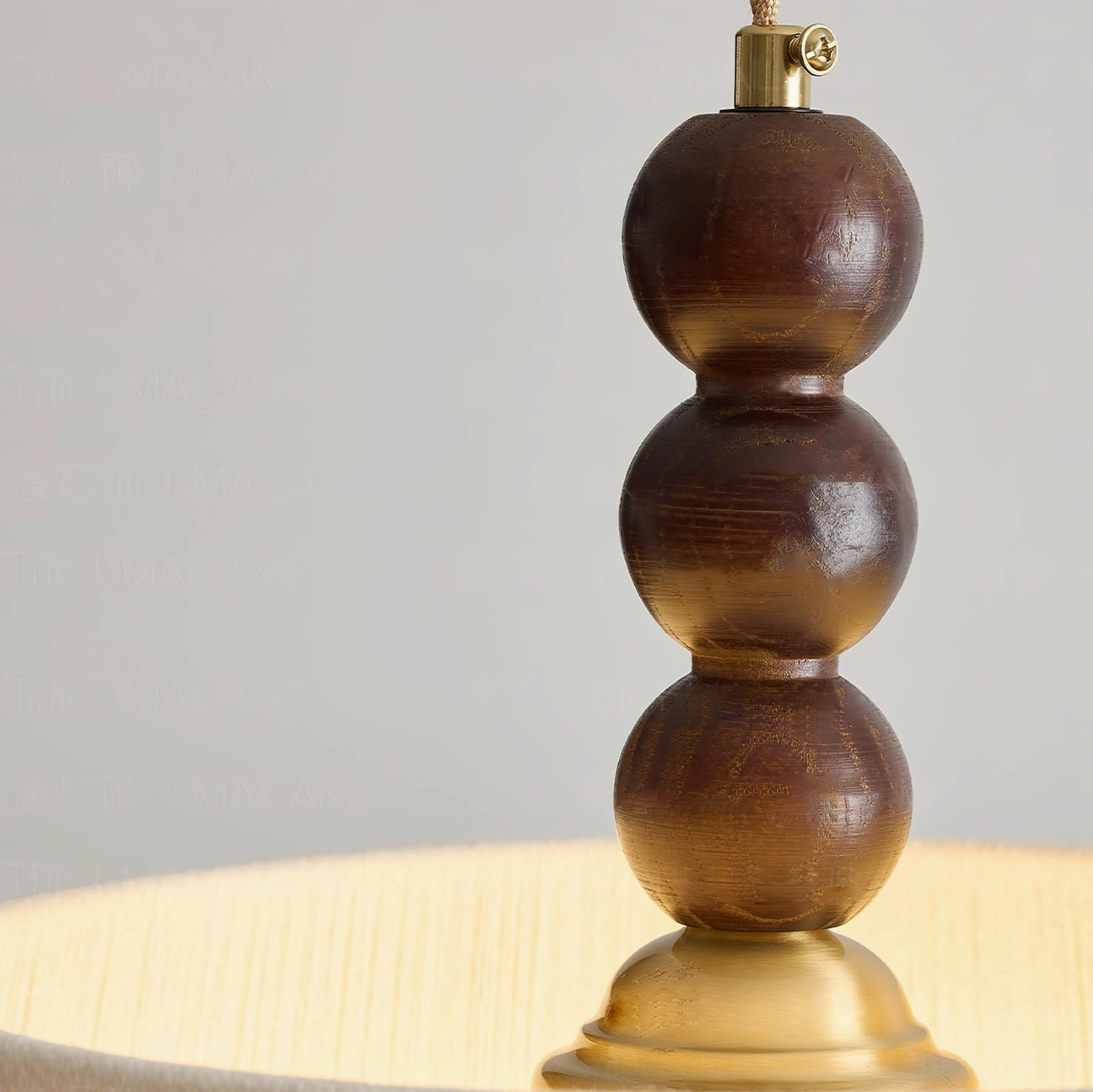 Lytham pendant light finial close-up featuring solid walnut wood spherical beads and brass metal components