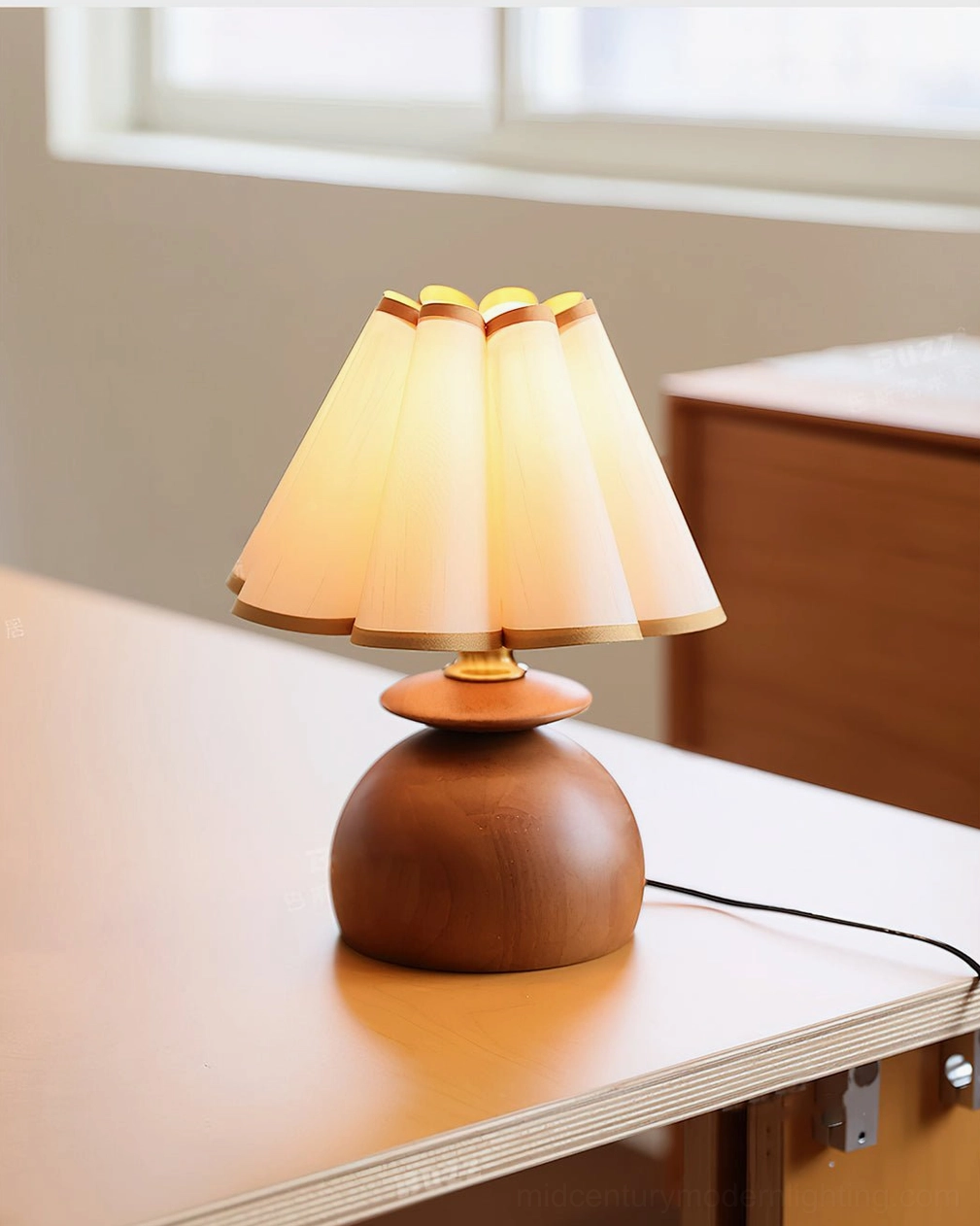 Mabel pleated table lamp three-quarter front view on desk by window with warm ambient glow