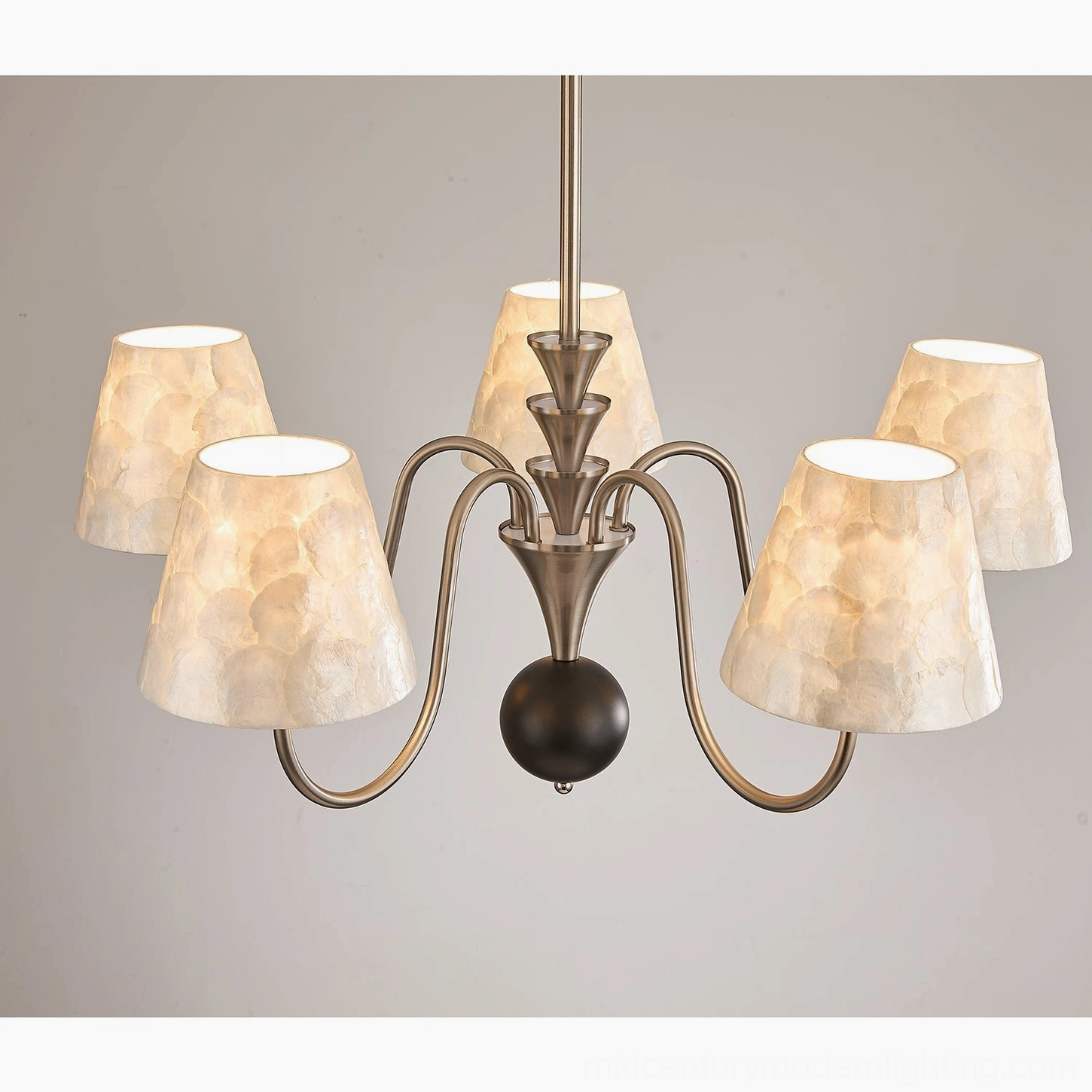 Close-up overhead detail of capiz shell chandelier showing curved metal arms and textured shell shades
