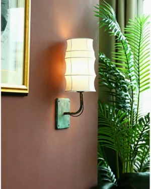 Japandi wall sconce mounted on terracotta accent wall with warm ambient lighting and home décor