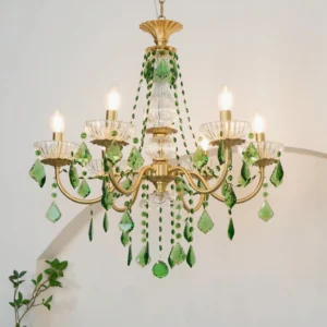 Magdalena brass chandelier with green crystals illuminated in home interior with warm lighting