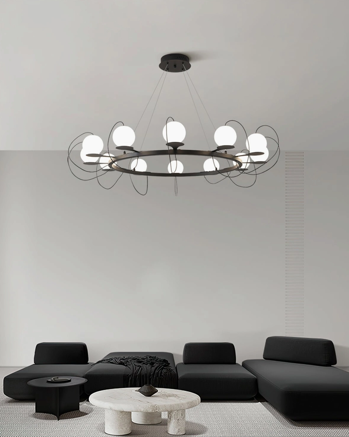 Mid-century modern magnetic bubble chandelier installed above minimalist black sofa in contemporary living room