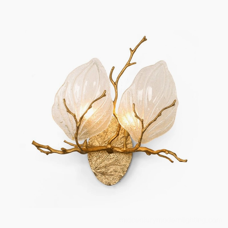 Magnolia branch brass sconce architectural detail showing textured frosted glass leaves and hand-cast brass craftsmanship