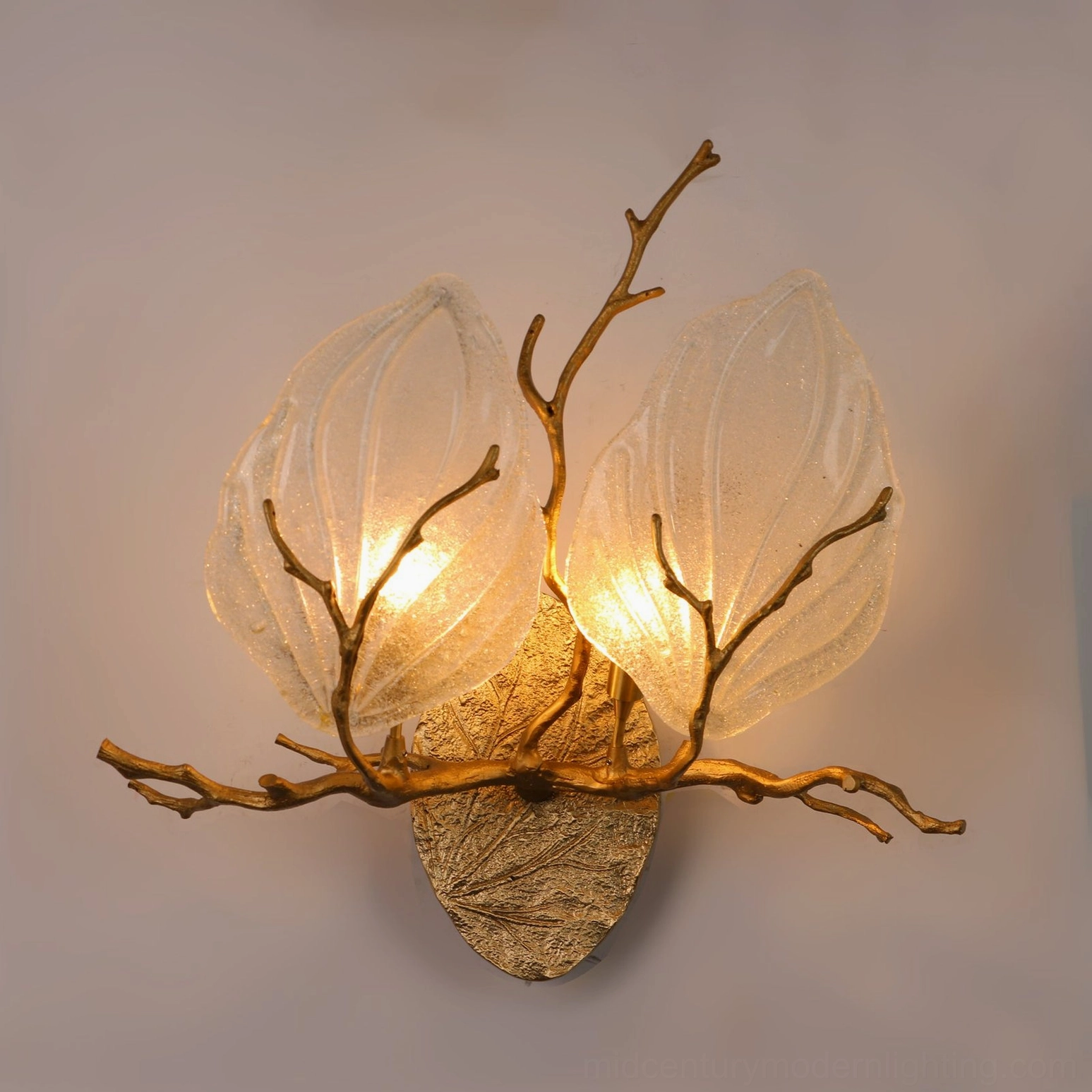 Magnolia brass wall sconce with hand-cast branch and frosted glass leaves showing G9 socket illumination and botanical design