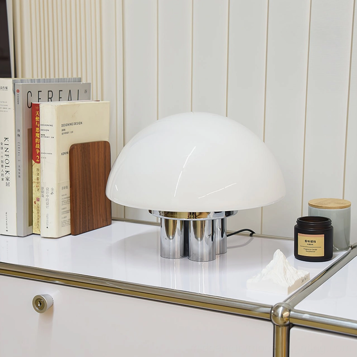 Luxury minimalist mushroom lamp with opal glass shade on white dresser with books and candles