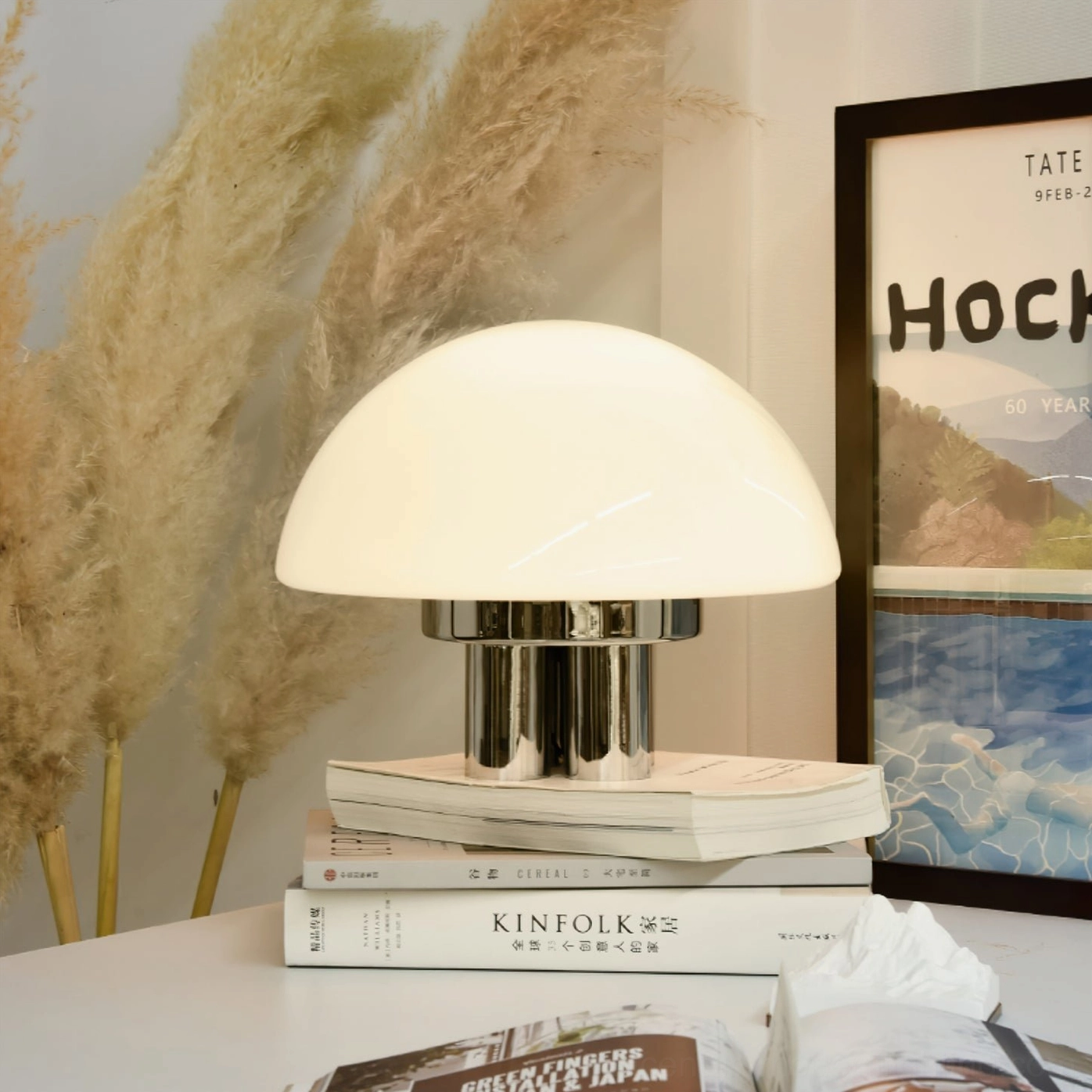 Mushroom table lamp on side table with stacked books and pampas grass home decor styling