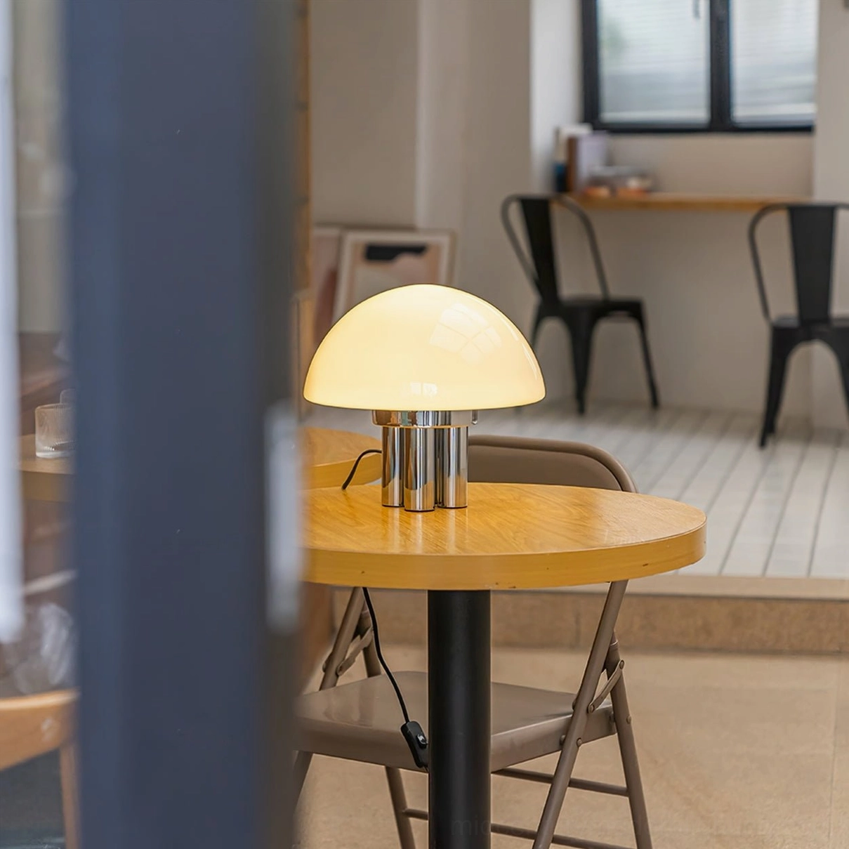 Vintage mushroom lamp on wooden cafe table through glass partition retro minimalist style