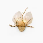 Magnolia leaf brass wall sconce with dual frosted glass leaves and hand-cast horizontal branch on white studio background