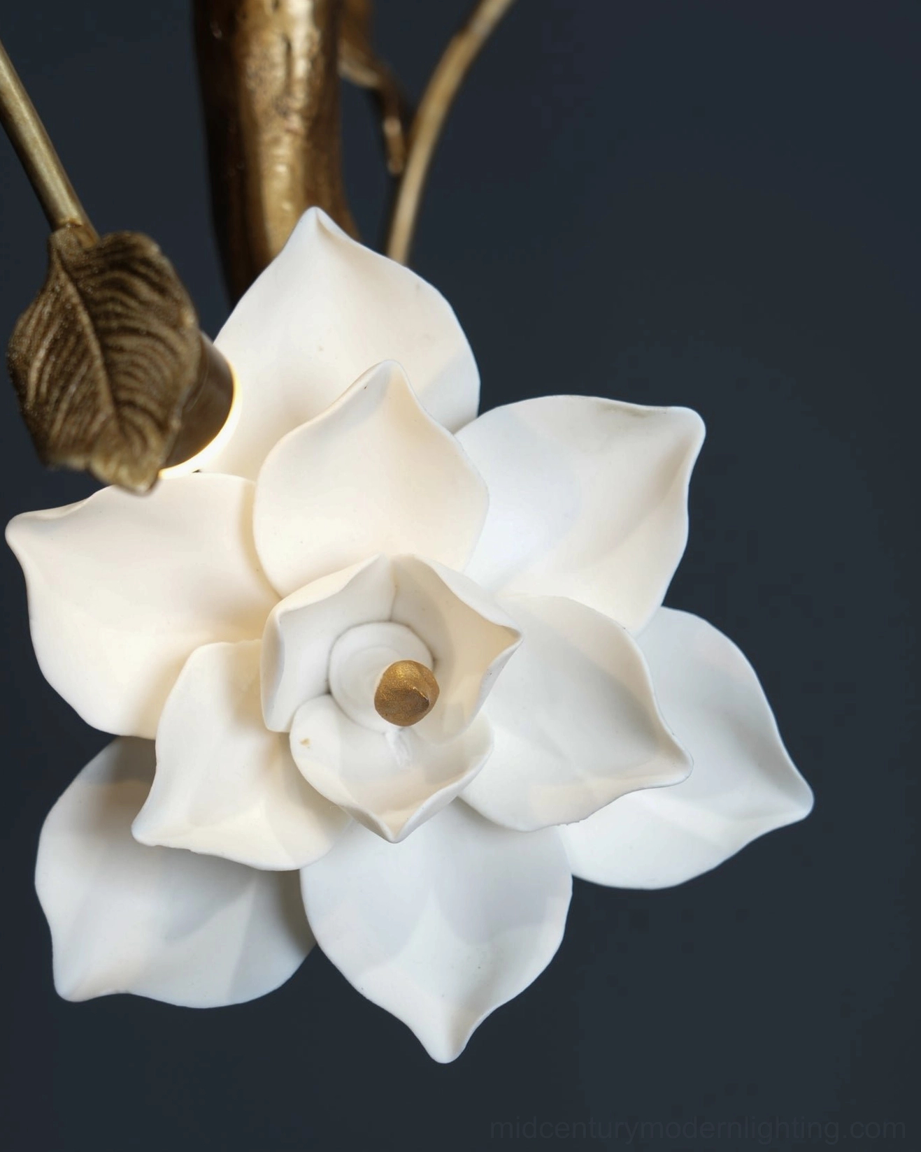Magnolia flower pendant light with warm brass patina and hand-molded white ceramic blooms, detail perspective