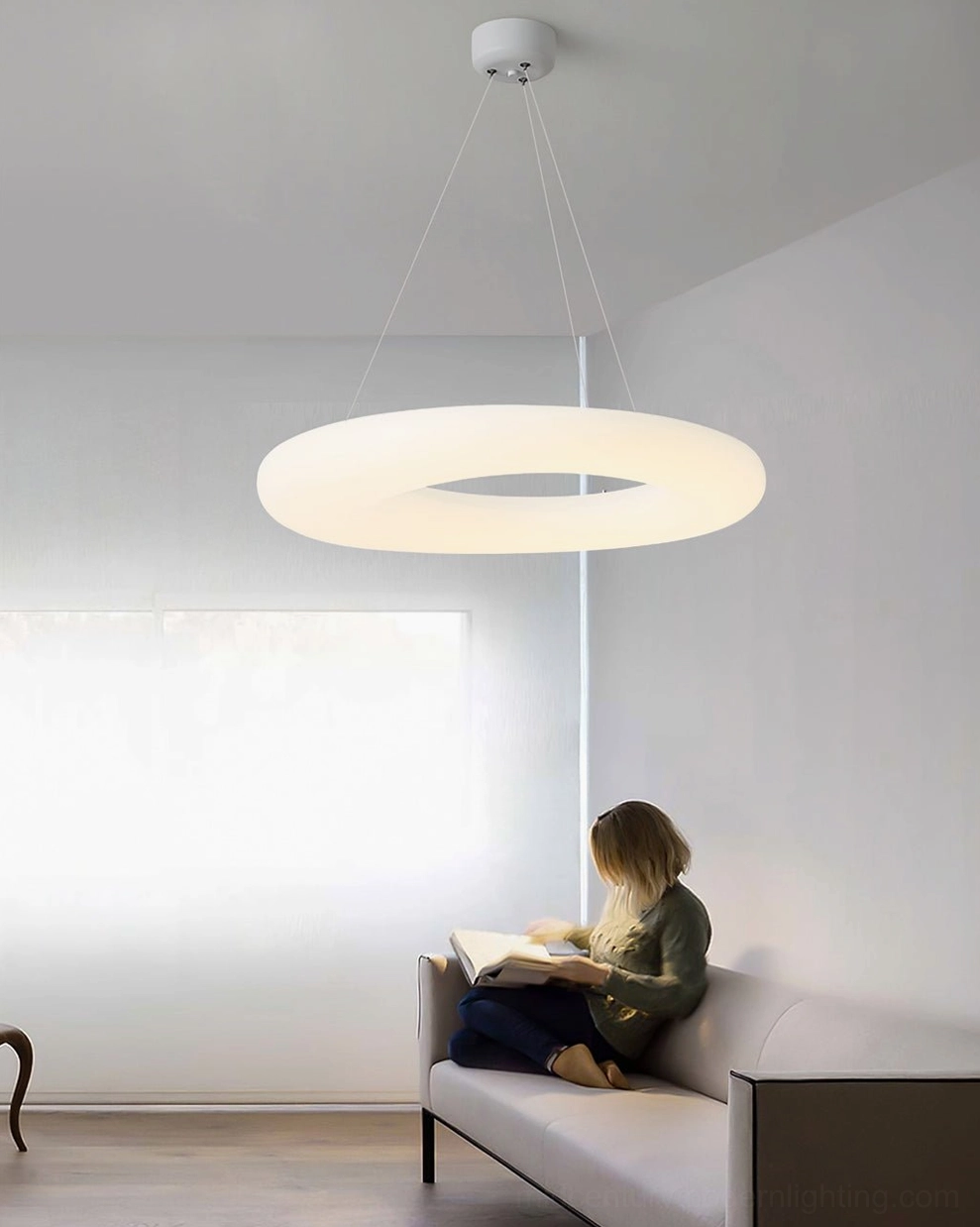 Magoo pendant light above comfortable living room sofa in warm cozy setting