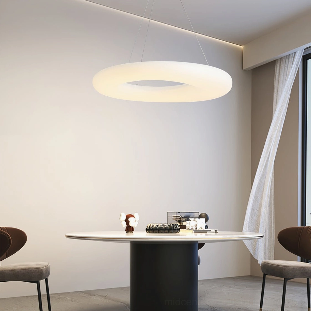 Magoo LED pendant lamp illuminated above modern dining table in warm light setting
