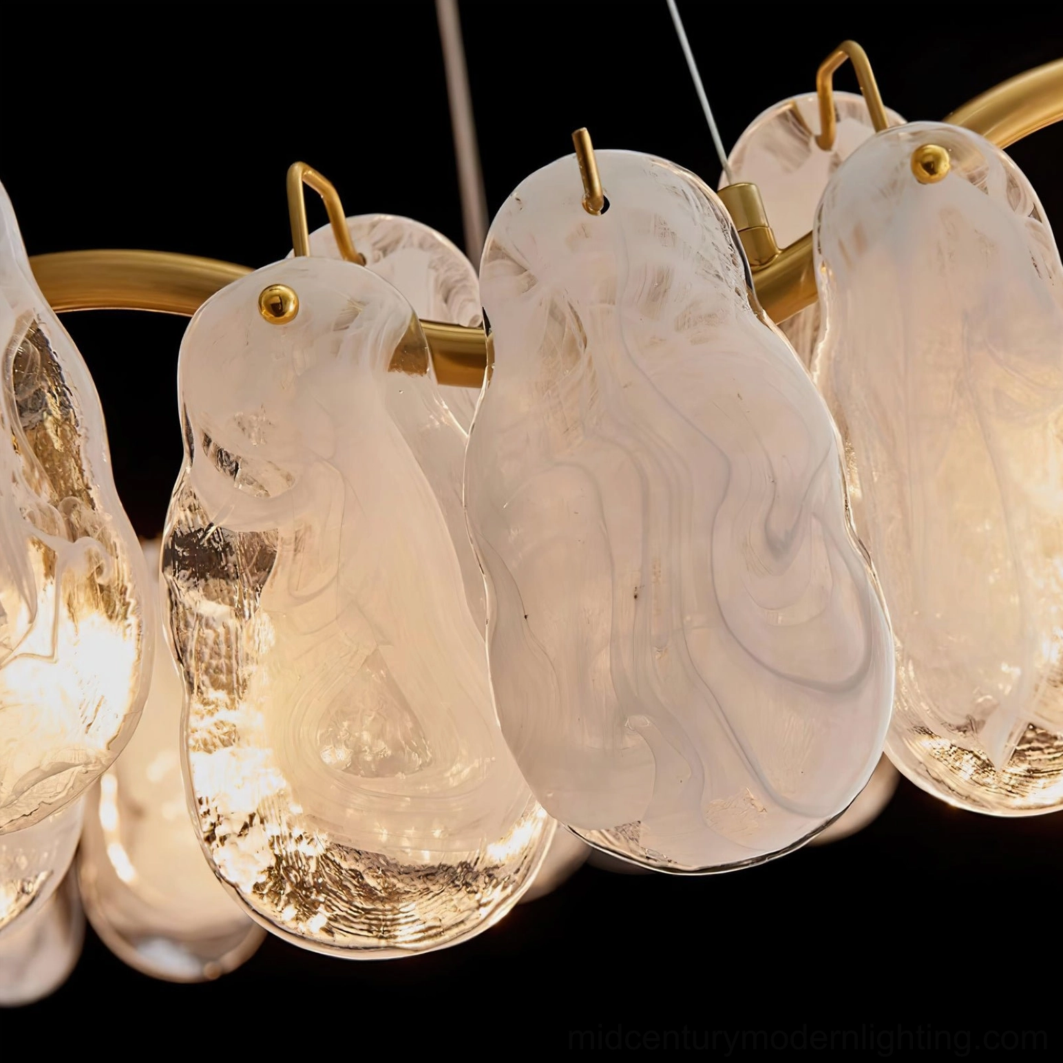 Close-up macro photography of cloud glass shade assembly showing marbled texture, brass gold mounting hooks and warm glowing bulbs detail