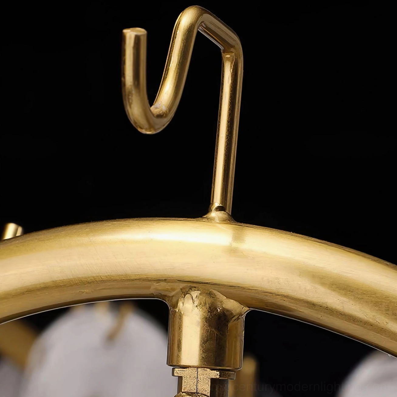 Chandelier suspension hardware detail showing brushed brass metal finish curved hanging hook and professional installation components