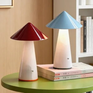Two Maisie rechargeable table lamps in contrasting colors displayed on side table with stacked books, showcasing mid-century modern design