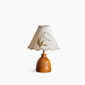 Maisie hand-embroidered table lamp with carved walnut wood base and cream fabric shade featuring scalloped edge, front studio view