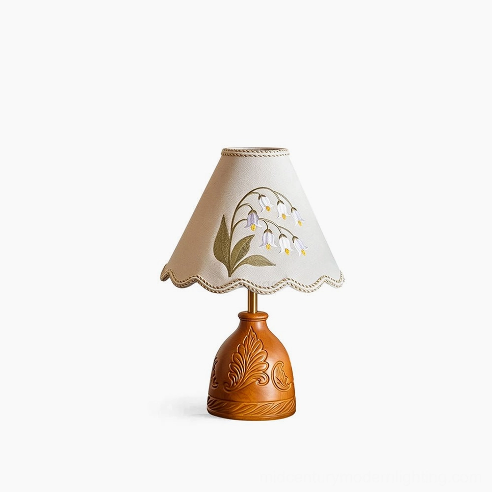 Maisie hand-embroidered table lamp with carved walnut wood base and cream fabric shade featuring scalloped edge, front studio view