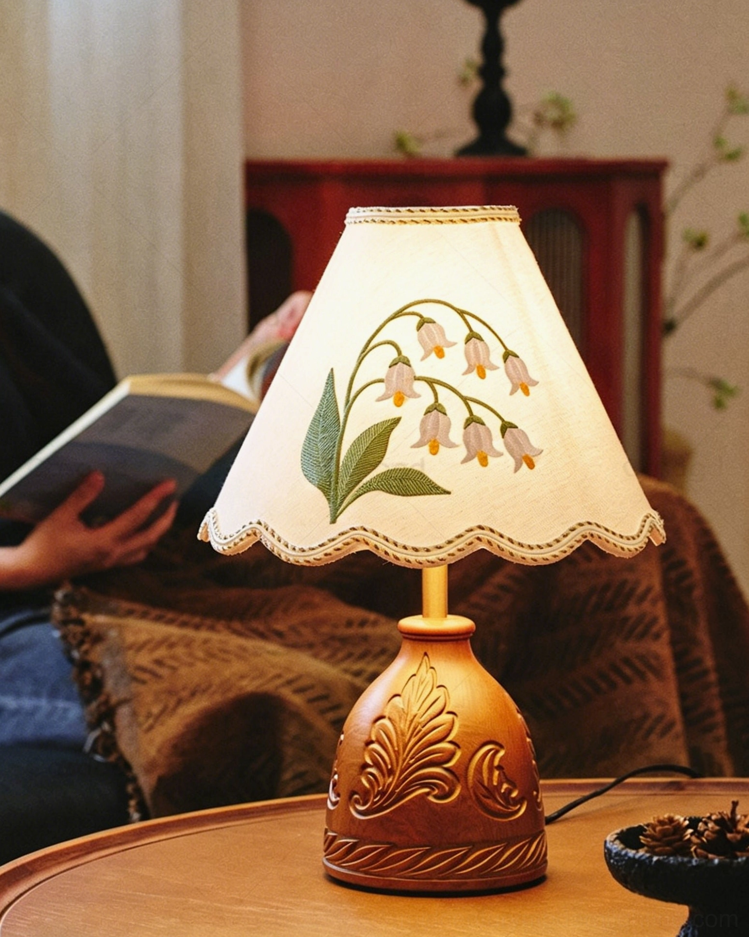 Maisie hand-embroidered table lamp showing carved wood base texture and leaf embossed details close-up