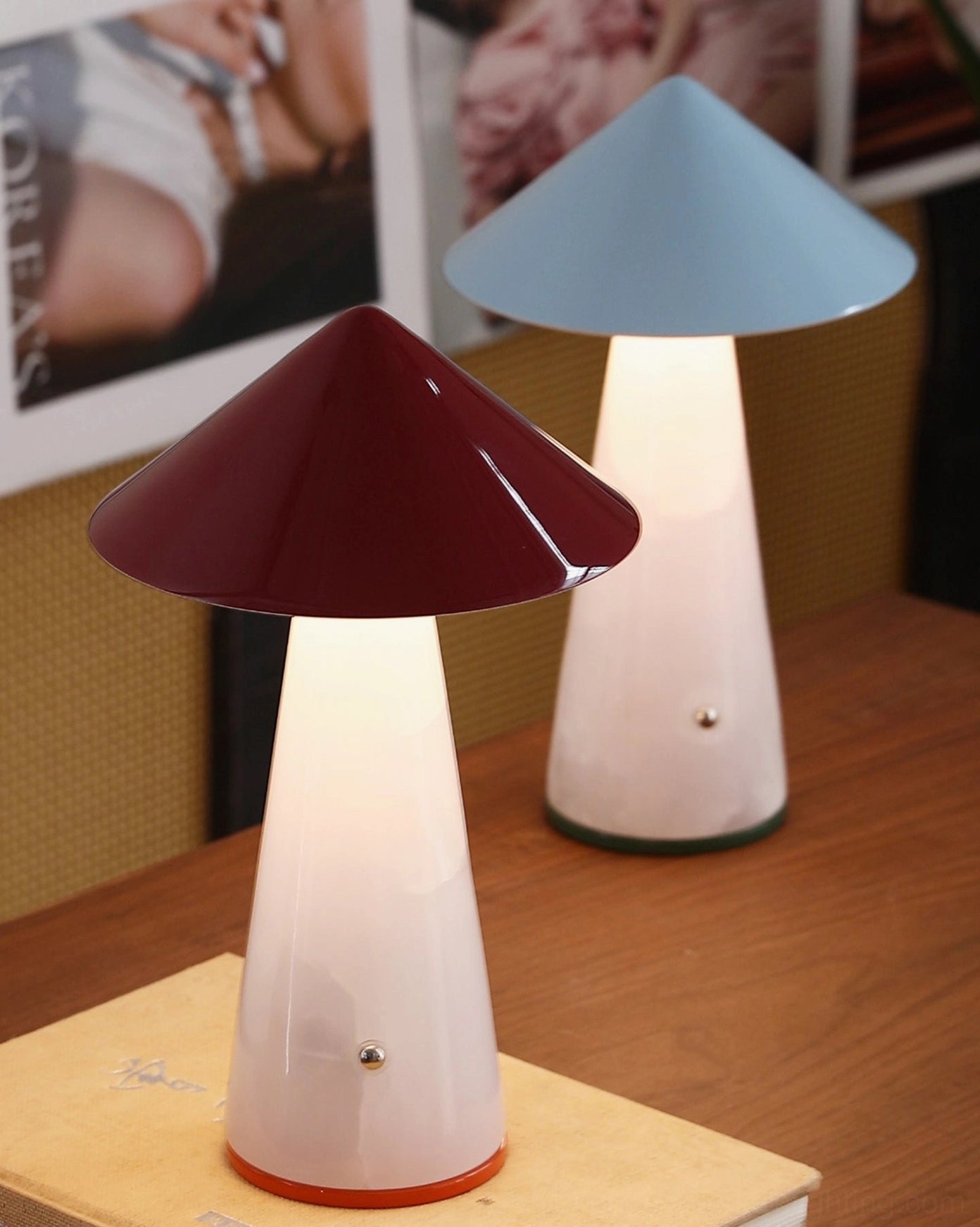 Two Maisie cordless table lamps glowing on wooden table next to book, showing warm ambient lighting from built-in battery LED