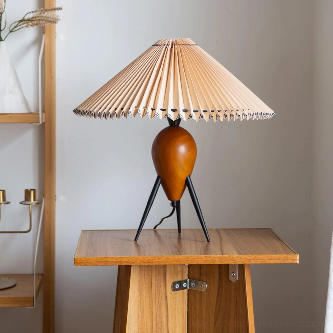 Makie tripod table lamp on wooden side table with candle holders and dried wheat, minimalist home styling