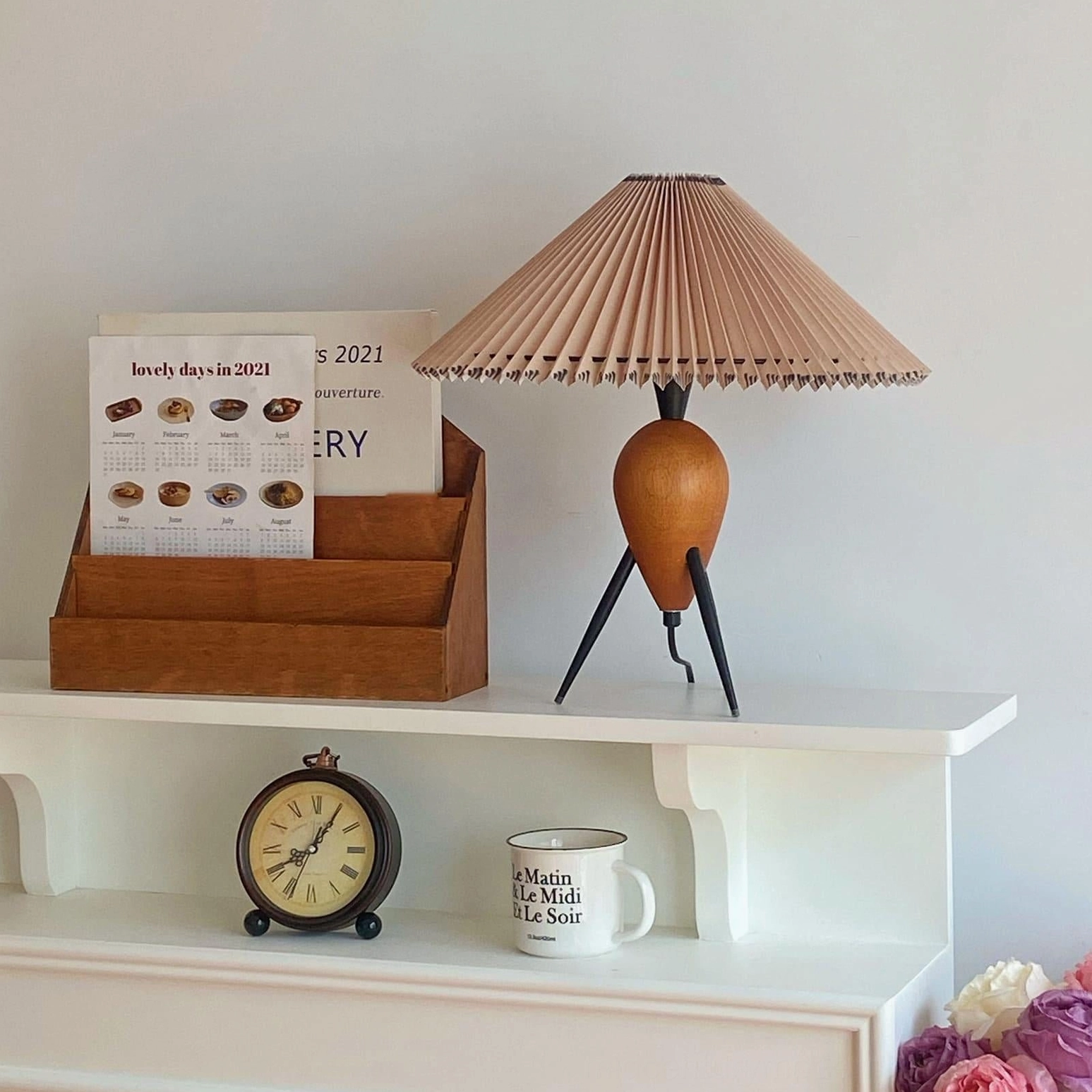 Makie tripod table lamp three-quarter view highlighting geometric tripod base and shade proportions
