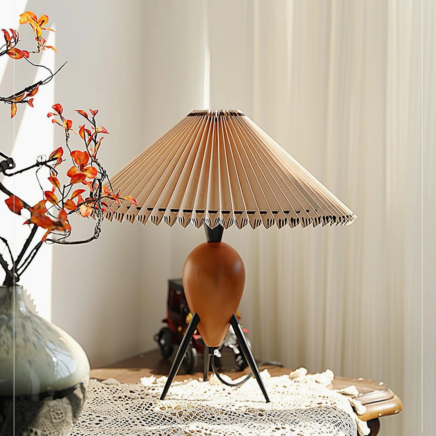 Makie mid-century tripod lamp on lace tablecloth with vintage accessories and red branch vase