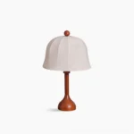 Malcolm mid-century modern table lamp with white embroidered dome shade and brown wooden base, studio front view