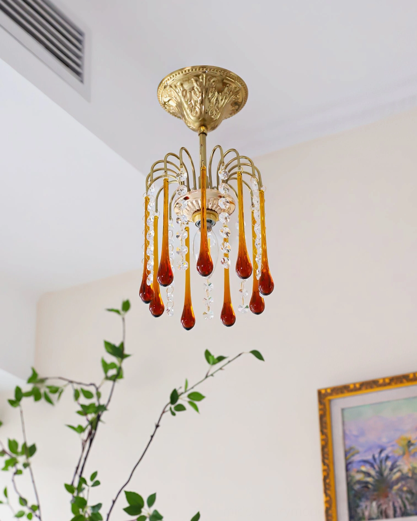 Low angle view of Maltose ceiling light with warm glowing interior bulb, vintage French design with brass and crystal details