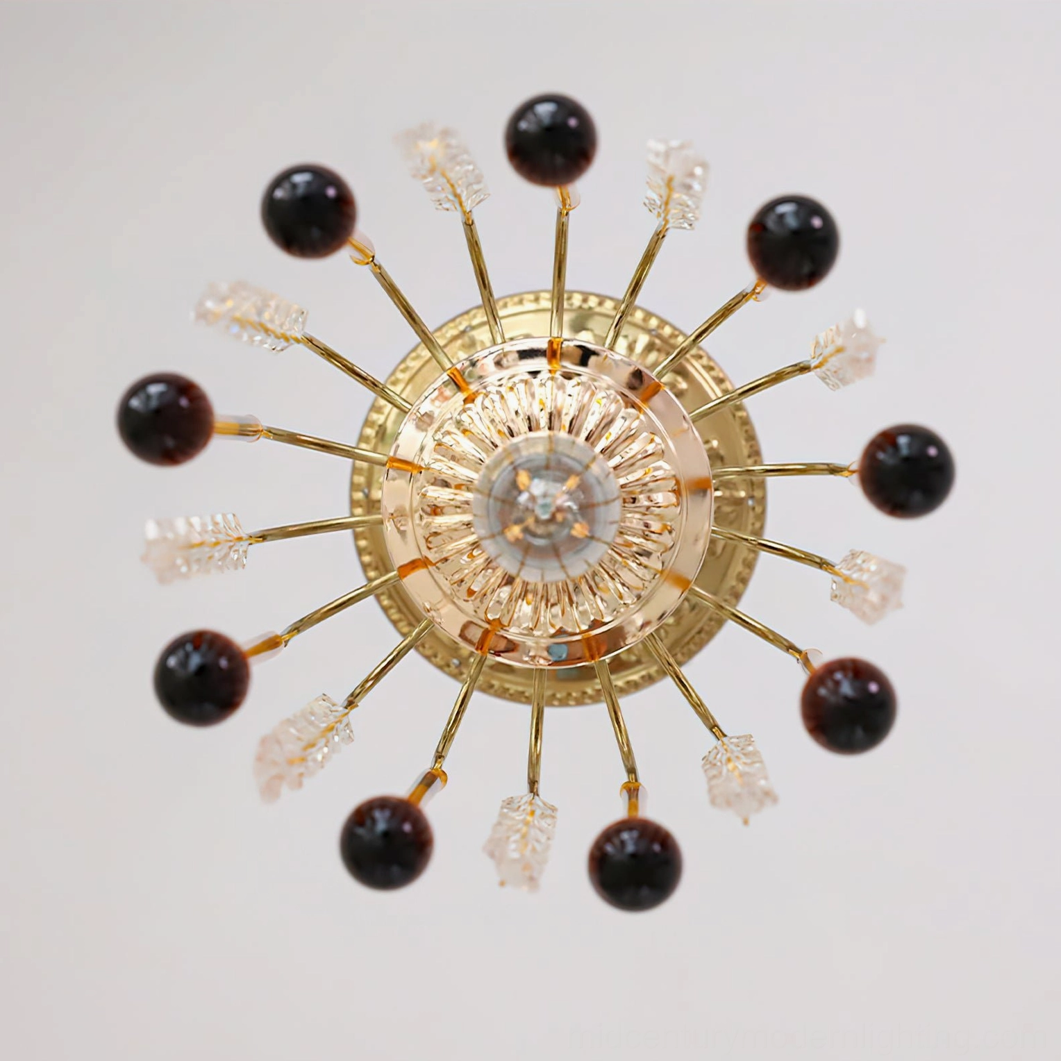 Sunburst mid-century modern style Maltose ceiling light with brass frame and glass orb accents in white studio background