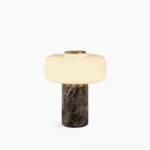 Marble cylinder table lamp with frosted glass diffuser, front flat studio view showing dark veined marble base and brass top accent